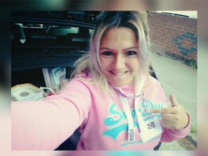 picture of raquel in a car pointing at her badge