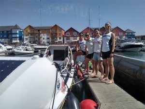 bristol girls team standing next to boat