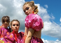3 females posing in a field wearing college fashion pieces