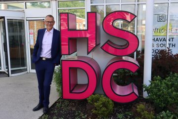 Mike Gaston leans against HSDC sign