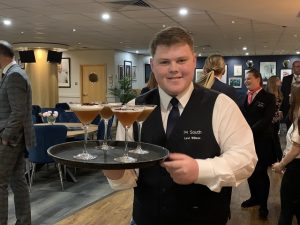 Student serving a tray of mocktails